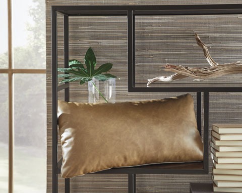 Modern geometric shelf with a brown leather pillow, a plant in a glass jar, a dried branch, and stacked books.