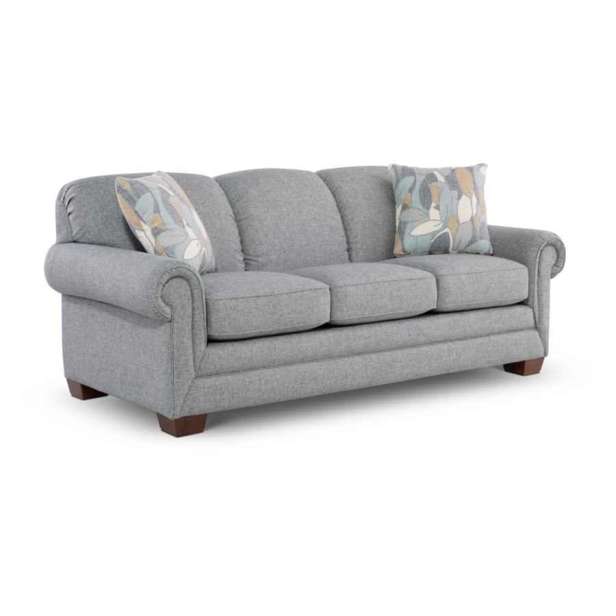 Grey fabric sofa with two patterned throw pillows on a white background, front view showing three-seat cushions and wooden legs